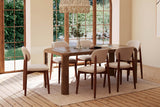 Tristan mango wood dining table in a bright room with arched windows and a beamed ceiling