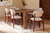 Tristan brown dining table with six upholstered chairs beside a wooden arched door