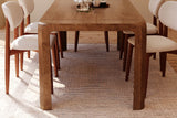 Tristan mango wood dining table seen from the end with chairs along both sides