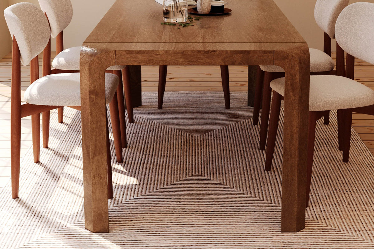 Tristan mango wood dining table seen from the end with chairs along both sides