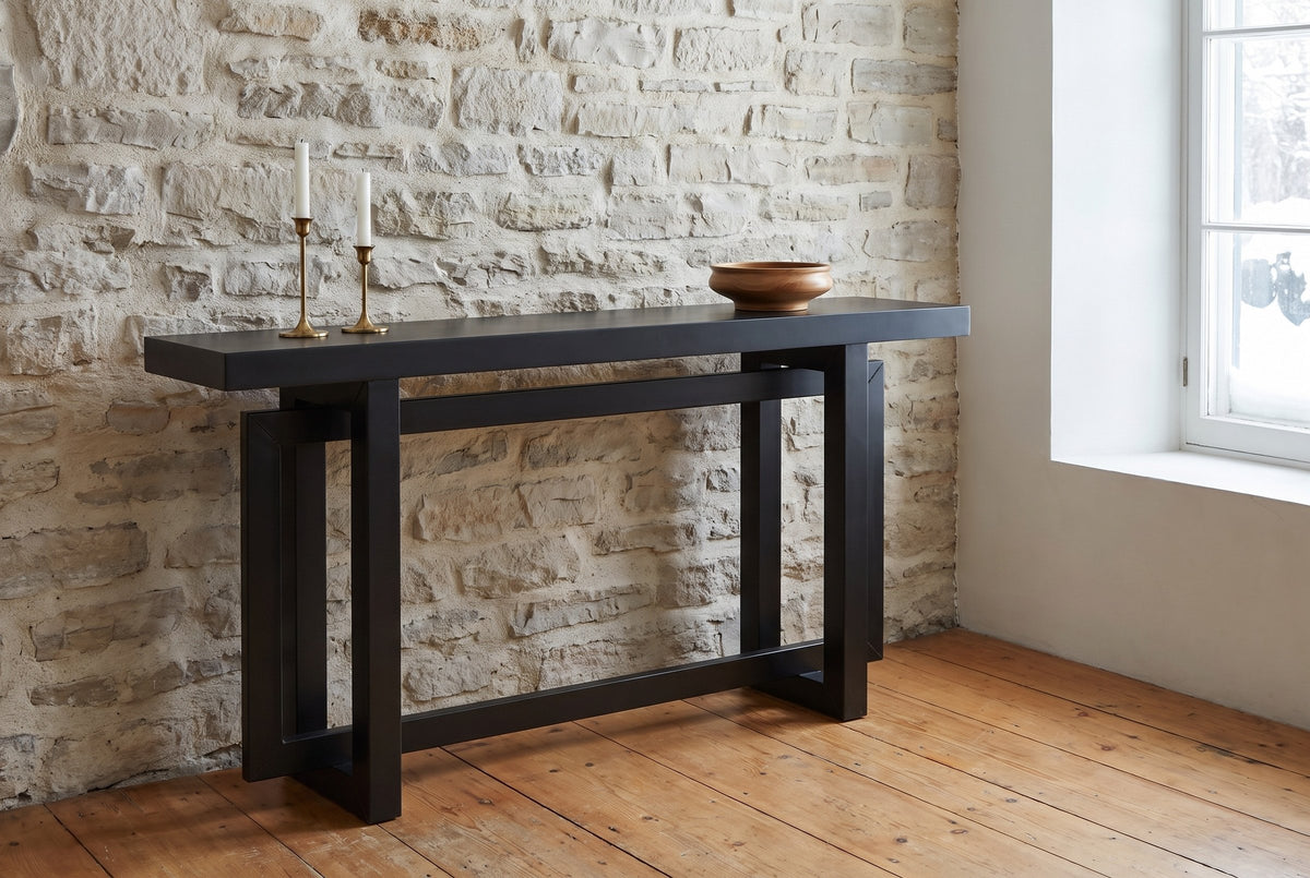 Urbania console table against an old limestone wall, brass candlesticks and a wooden bowl on top