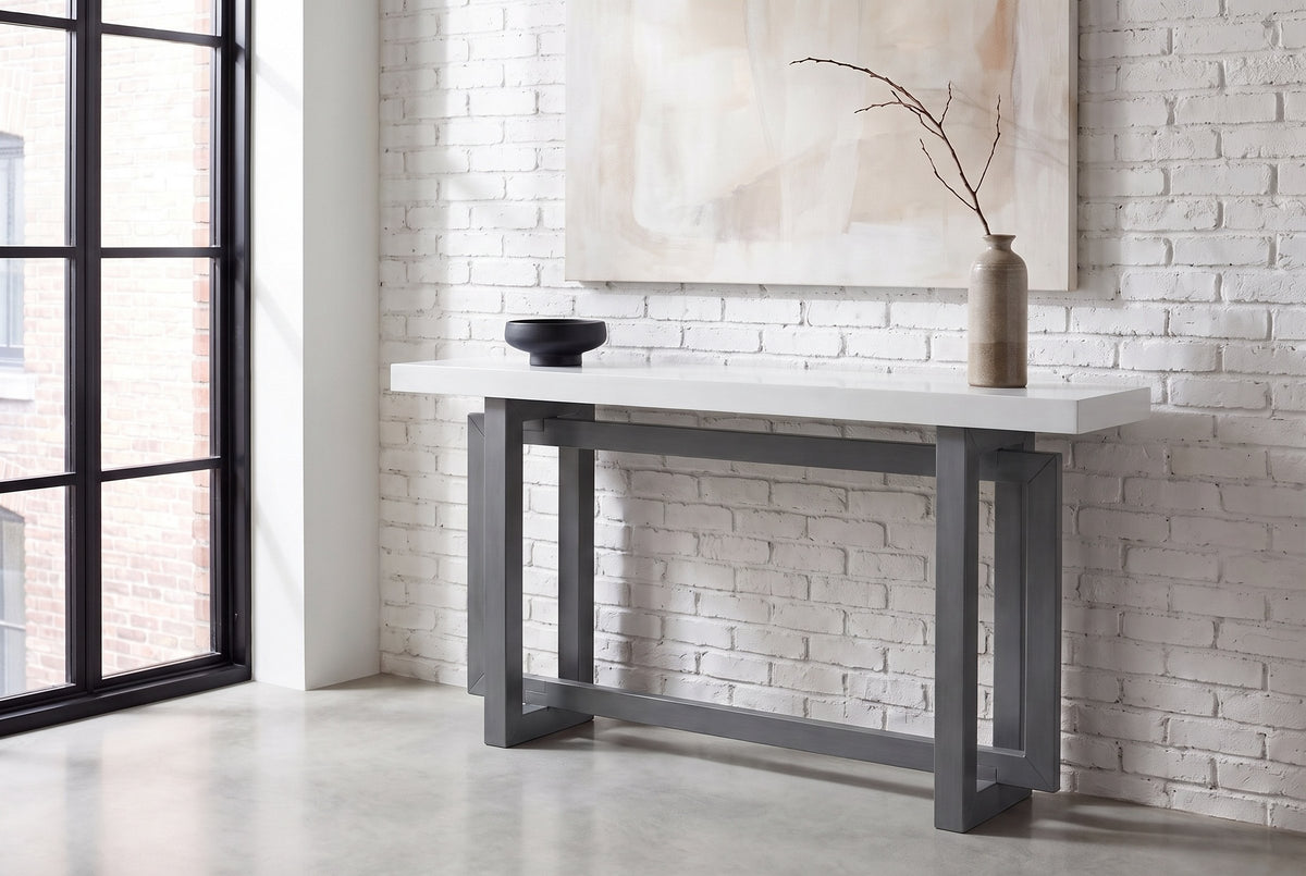 Urbania console table in Dark Gray + White against a whitewashed brick wall in a loft entry, a branch in a stoneware vase