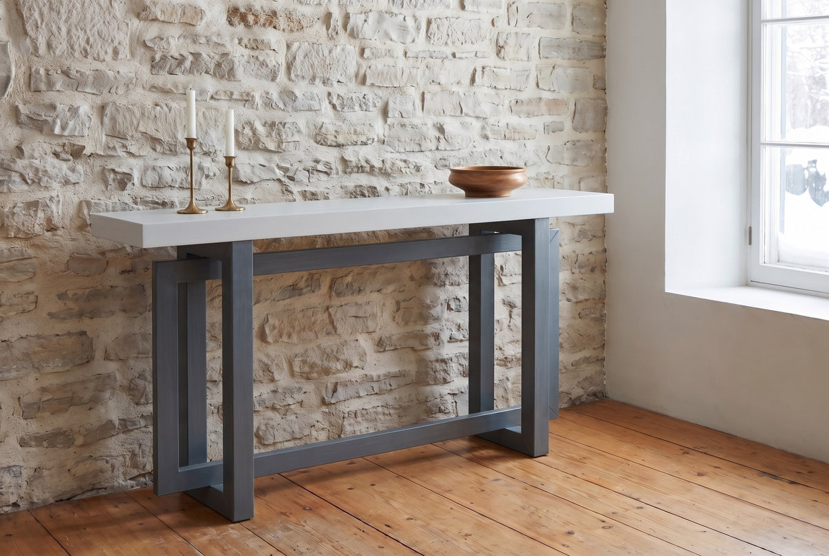 Urbania console table in Dark Gray + White against an old limestone wall, brass candlesticks and a wooden bowl on top