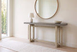 Urbania console table in Gray in a bright entry under a round oak mirror, a white lamp and a stone bowl on top