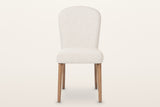 Usseglio dining chair, straight front view: the arched upholstered back, the thick seat and four ash legs