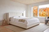 Varenna boucle bed in a chalet bedroom with a pine ceiling and a window onto autumn maples