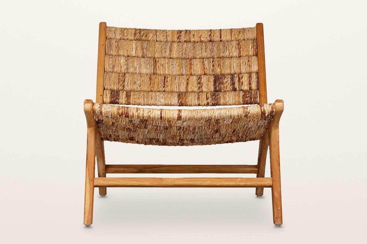 Varigotti accent chair, straight front view on a warm white studio backdrop: the wrapped abaca back and seat between the teak