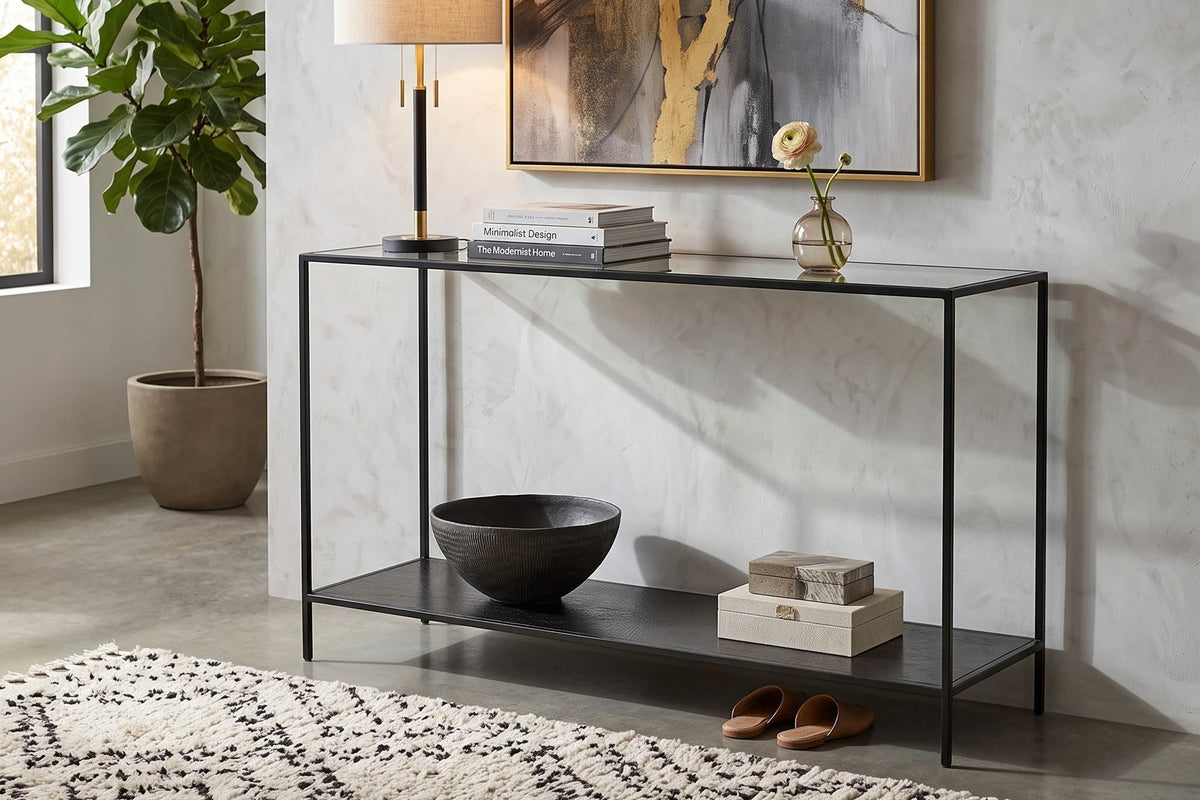 Vaughn console table in an entryway with a table lamp, books and a bowl on the lower shelf