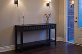 Black Velletri console table in an Ottawa townhouse front hall at dusk, iron sconces lit