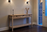 Velletri console table in an Ottawa townhouse front hall at dusk, iron sconces lit, a candlestick and dried grasses on top