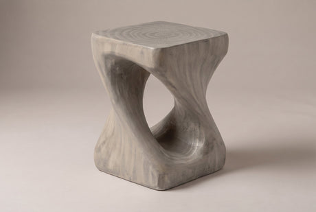 Vicenza twisted side table in Grey, seen from the corner on a warm grey studio backdrop: square top, oval opening