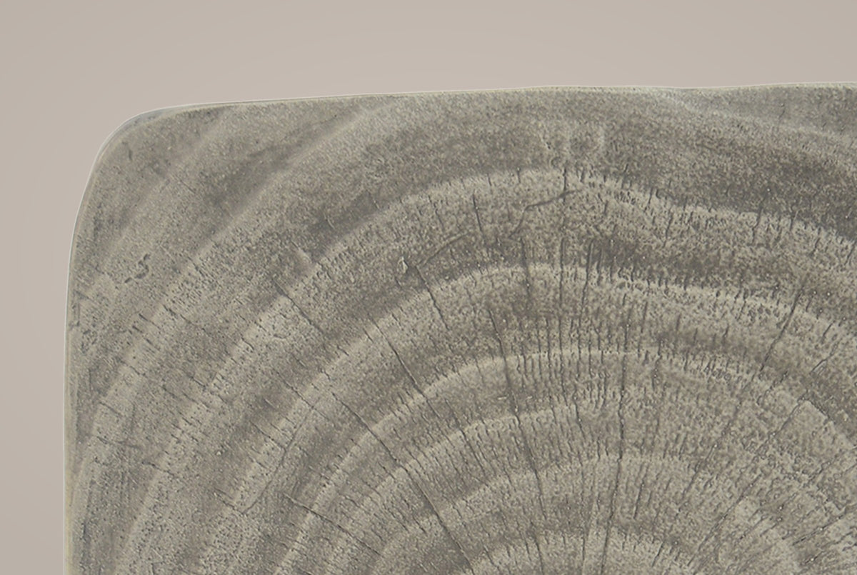Close-up of the Grey top corner: cast tree rings and fine radial cracks in soft driftwood grey, the rounded edge