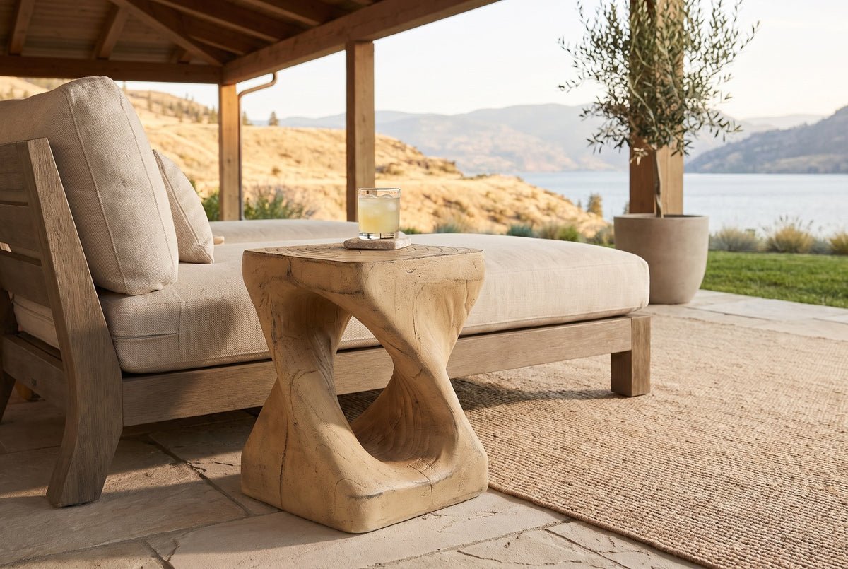Vicenza side table beside an outdoor lounge on a covered Kelowna patio, the lake and dry hills beyond