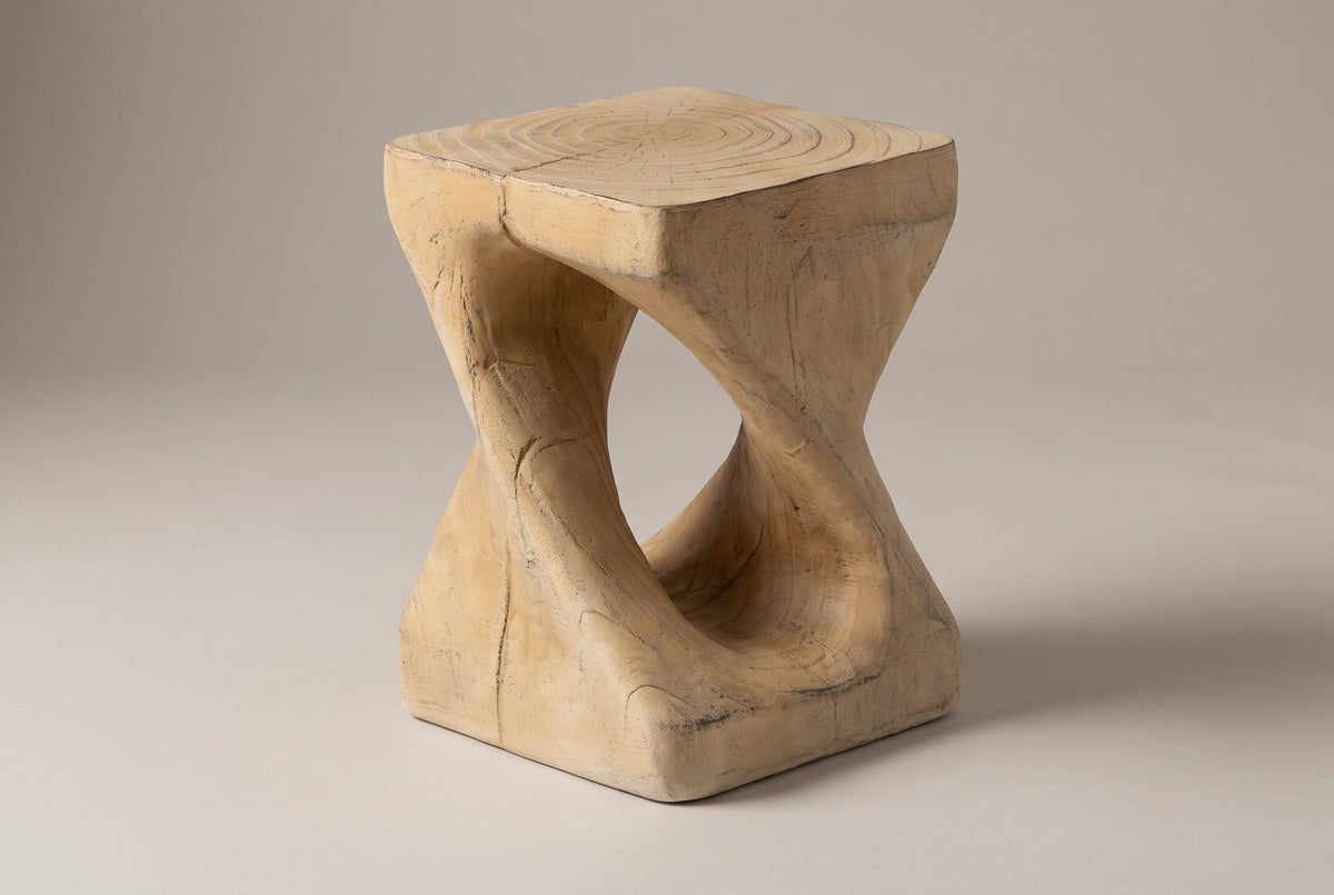 Vicenza twisted side table in Natural, seen from the corner on a warm grey studio backdrop: square top, oval opening