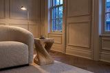 Vicenza side table beside a boucle armchair in a panelled Toronto front room at dusk, a cup and saucer on top