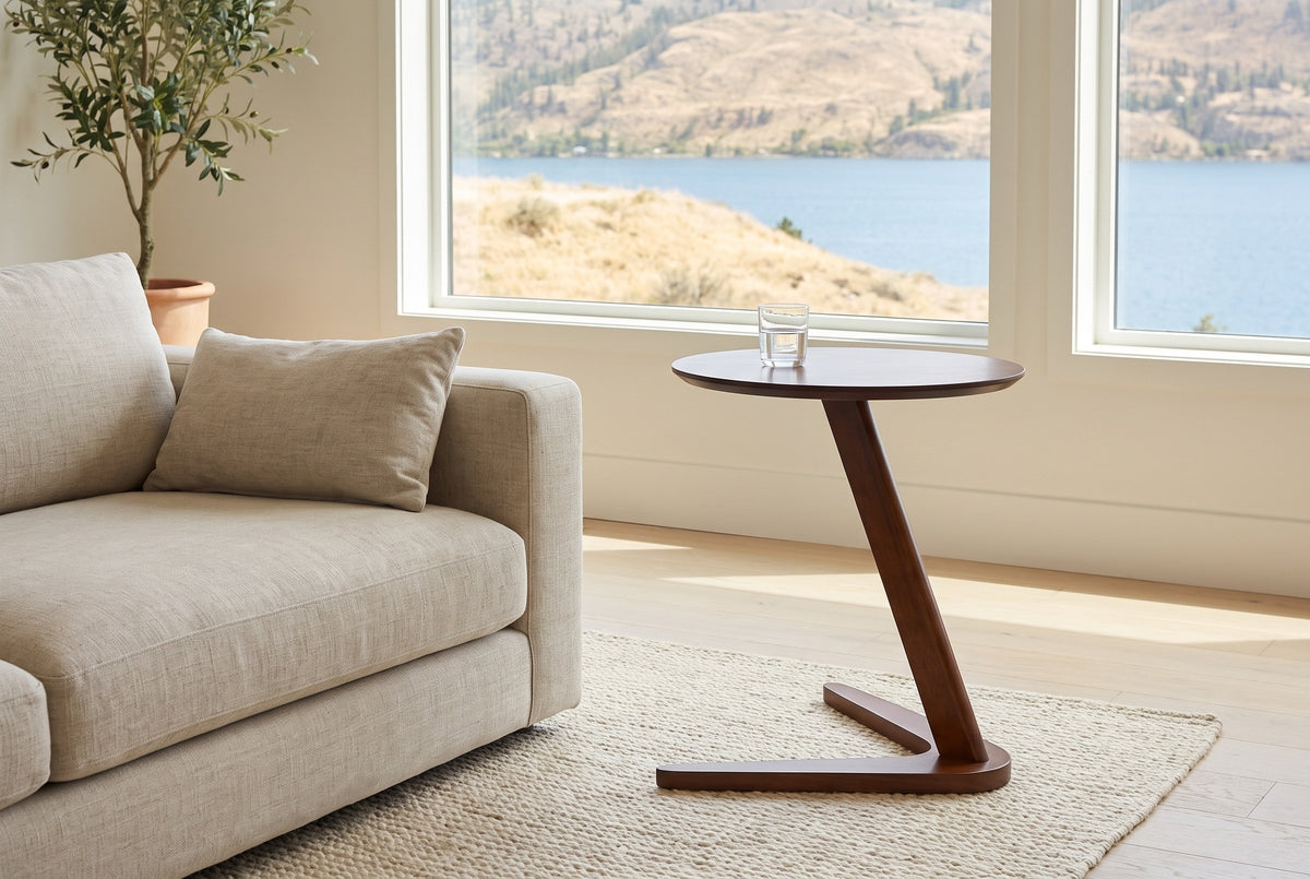 Vigevano side table beside an oatmeal linen sofa in a Kelowna lake house, a glass of water on top and the lake beyond