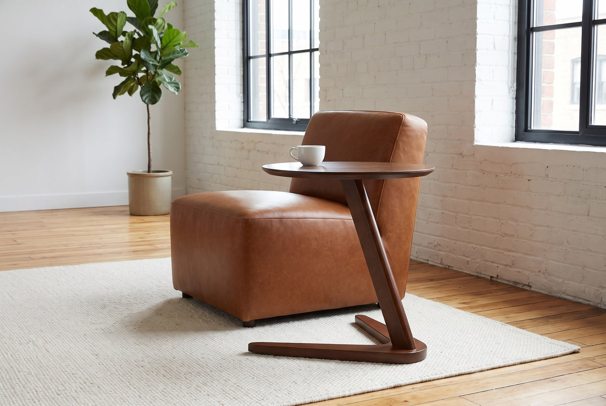 Vigevano side table in walnut beside a cognac leather chair in a Montreal loft with white brick walls, a white cup on top