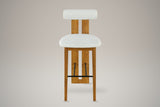 Vigoleno bar stool in Ivory, straight front view: cylindrical bolster back on a slotted walnut-finish plank