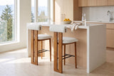 Two Vigoleno bar stools in Ivory at a white quartz island in a bright Vancouver kitchen with pale oak cabinets and a bowl