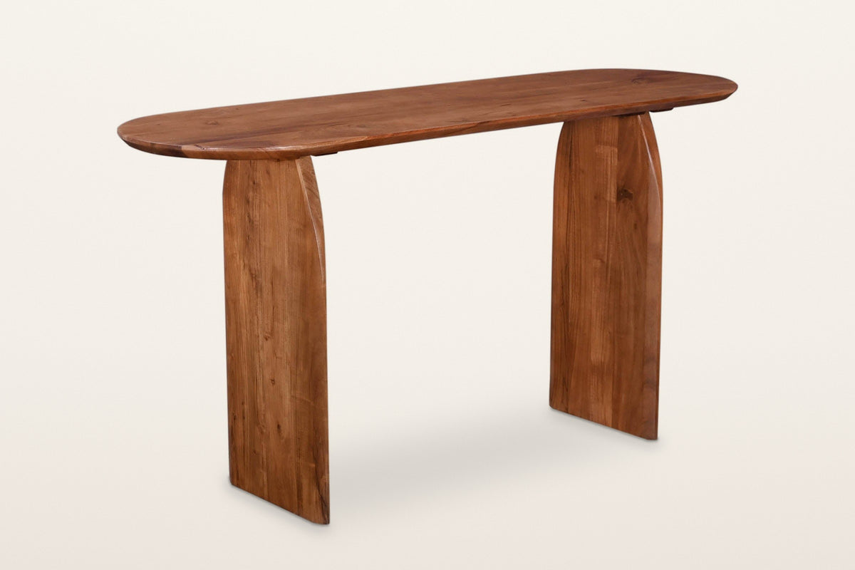 Visso solid acacia console table in Pecan, three-quarter view on a warm white studio backdrop: a long racetrack top on two ar
