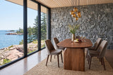 End view of the Visso dining table in Pecan in a Lake Superior house with a granite wall and a lake view