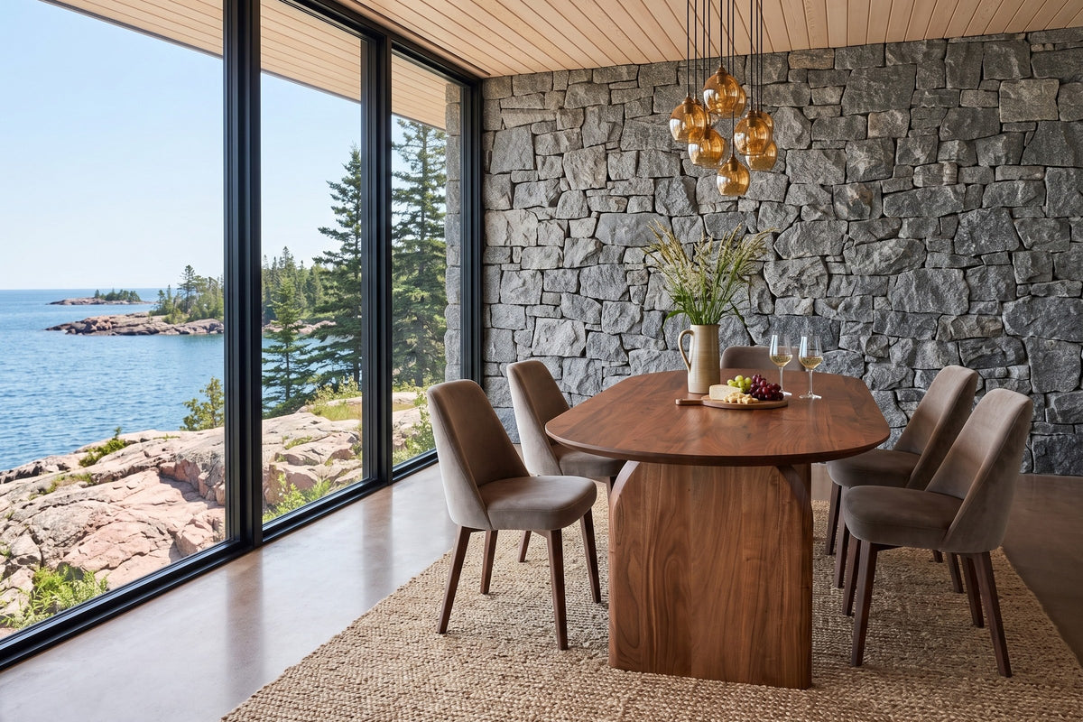 End view of the Visso dining table in Pecan in a Lake Superior house with a granite wall and a lake view