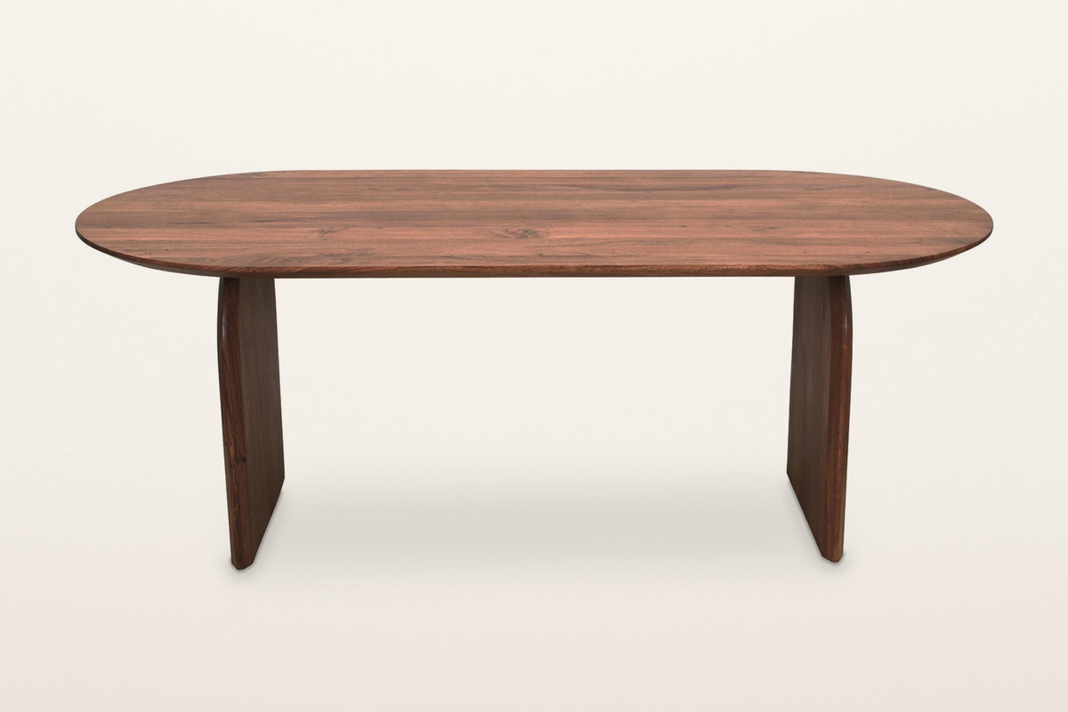 Visso dining table in Pecan, straight front view on a warm white studio backdrop: a thin top over two slim panel legs