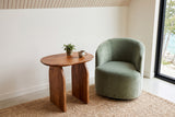 Visso side table in Pecan seen from above beside a sage velvet swivel chair in a Manitoulin Island house
