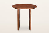 Visso side table in Pecan from the long side, on a warm white studio backdrop: the oval top