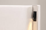 Close-up of a Viterbo reading lamp on the inside of the wing: black plate, swing arm, warm LED, USB port and switch