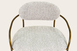 Close-up of the Vitorchiano counter stool from above: the Pearl Grey bouclé back pad and seat, the antique bronze arms curving round the seat