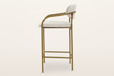 Vitorchiano counter stool in profile: the front leg bending back into the arm, the back pad on the rear legs, the footrest frame low down