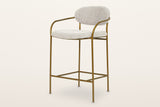 Vitorchiano arm counter stool in Pearl Grey bouclé on a slim antique bronze tube frame: an oval back pad, two bent-tube arms, four straight legs and a footrest frame, three-quarter view on a warm white studio backdrop
