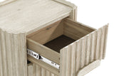Close-up of the Vitorchiano top drawer pulled out: the acacia drawer box on a metal glide behind the reeded front