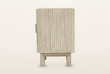 Side view of the Vitorchiano nightstand in Natural White Wash on a warm white studio backdrop: the reeded side over the plint