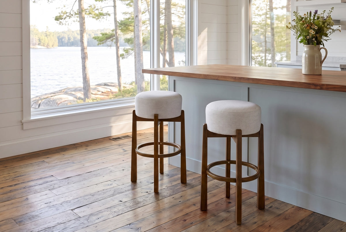 Two Dark Walnut Vogogna bar stools at a butcher-block island in a Muskoka cottage kitchen with a window onto the lake