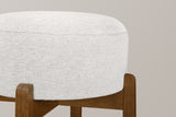 Close-up of the Vogogna ivory linen-look drum cushion held in the notched tops of the Dark Walnut legs