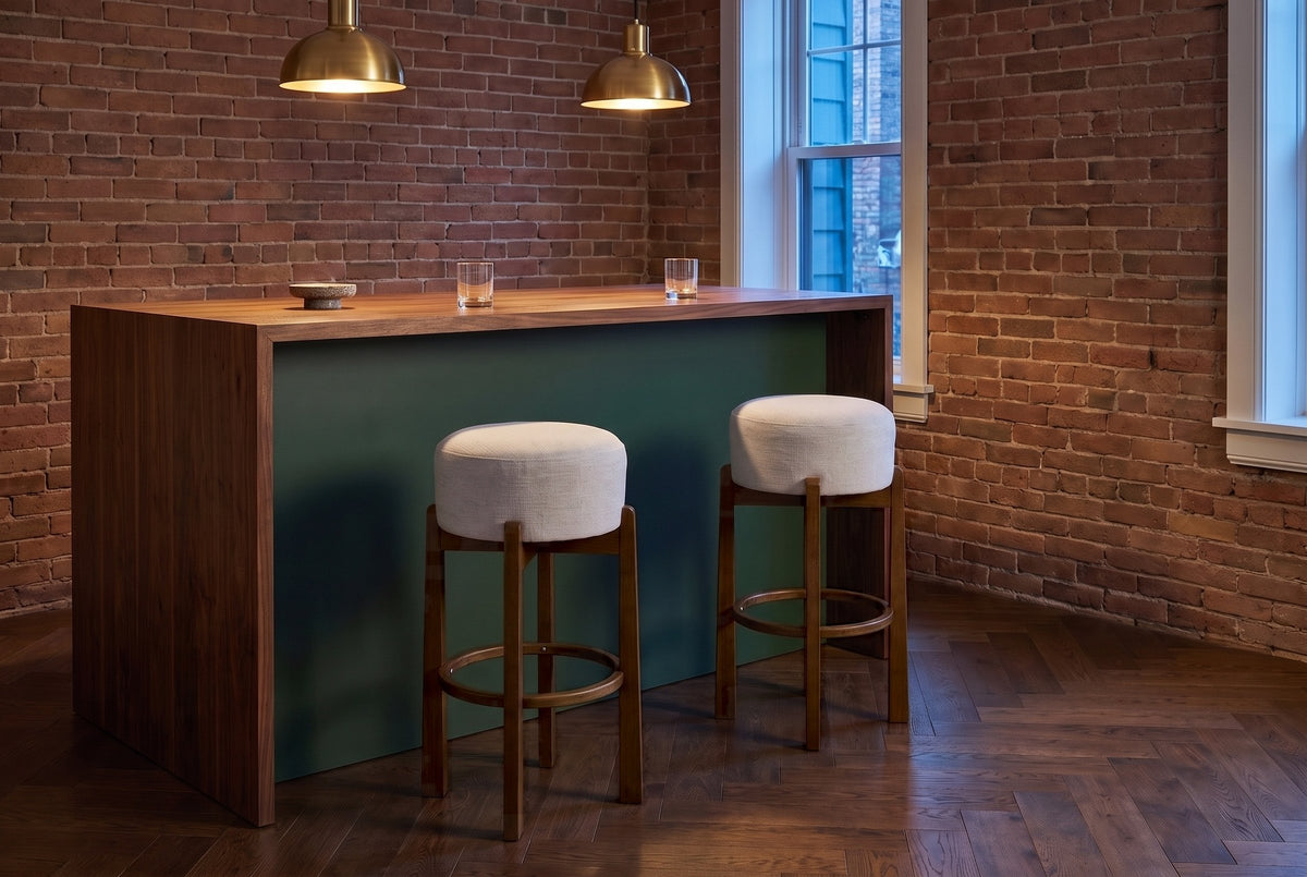 Two Dark Walnut Vogogna bar stools at a green and walnut bar counter in a Toronto brick room under brass pendant lamps