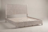 Volterra solid wood reeded bed in a pale whitewashed beige finish, three-quarter view on a warm off-white studio backdrop