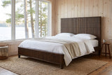 Volterra reeded bed in a pine-panelled lakeside cottage bedroom with a jute rug
