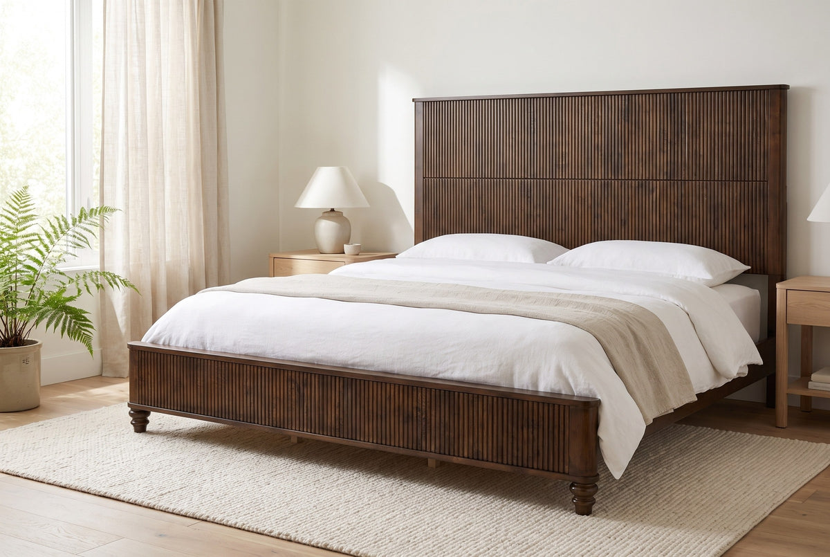 Volterra reeded bed in walnut made up with white linen, in a bright bedroom with a fern