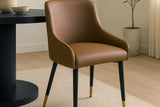 Wilkes brown faux leather dining chair beside a black round pedestal table on a cream rug