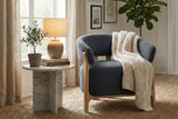 Willoughby chenille club chair with a knit throw beside a stone side table and lamp