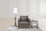 Yvette brass floor lamp beside a grey armchair in a panelled living room