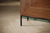 Black iron leg and fluted door of the Zephyr sideboard on a herringbone floor
