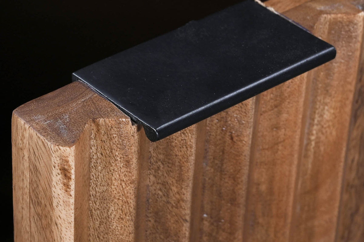 Black metal tab pull on a fluted mango wood door of the Zephyr sideboard